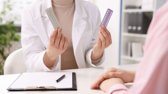 Médecin présentant deux types de pilules contraceptives à une patiente