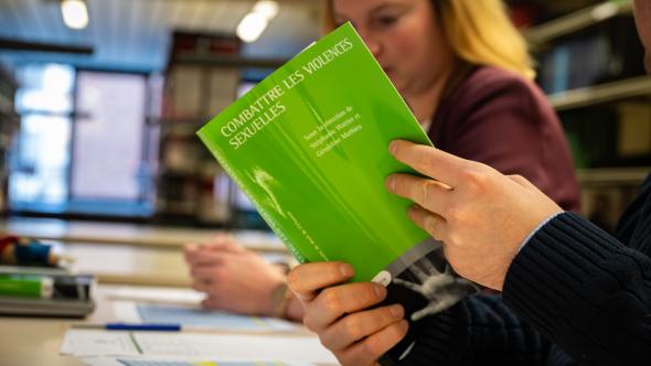 Photo d'une personne feuilletant le livre "Combattre les violences sexuelles"