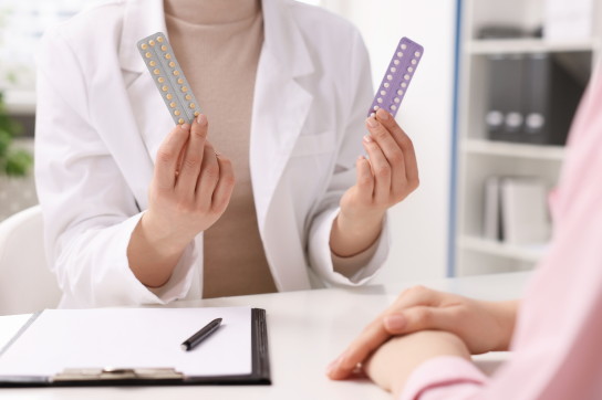 Médecin présentant deux types de pilules contraceptives à une patiente